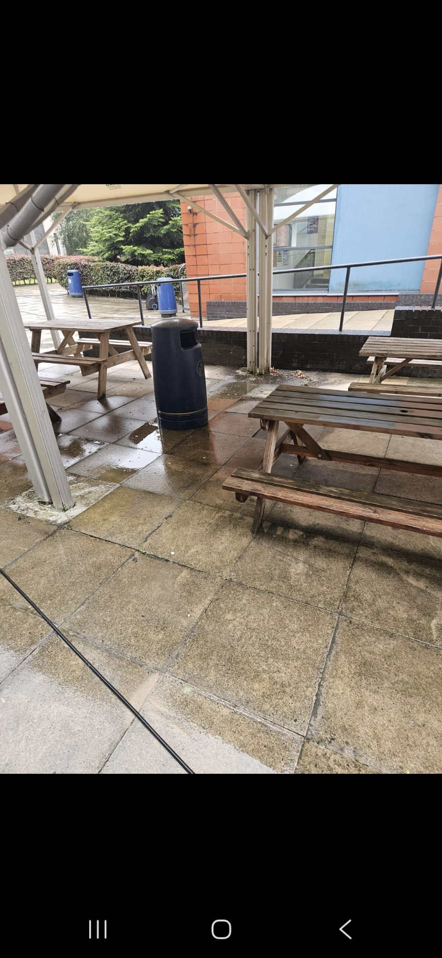 Commercial seating area part-way through a pressure wash
